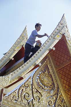 Photo of painter on Thai Pavilion roof