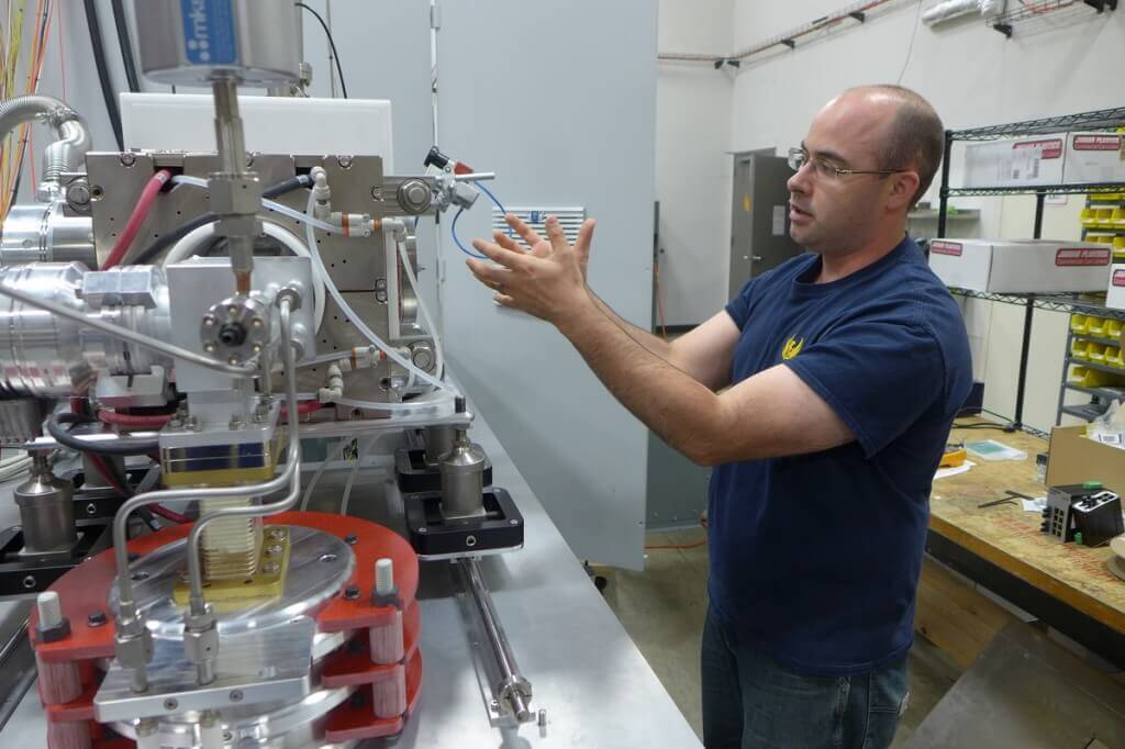 Ross Radel, president of Phoenix Nuclear Labs, explains a prototype of a negative hydrogen ion source. Developed with funding from the Department of Energy, this device has sparked interest in the semiconductor industry.Credit: David Tenenbaum/University of Wisconsin-Madison