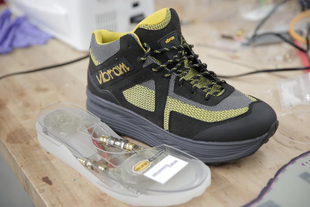A shoe sole with an embedded energy harvester sits next to a first practical footwear energy harvester developed by the UW–Madison researchers’ startup company, InStep NanoPower, and Vibram.