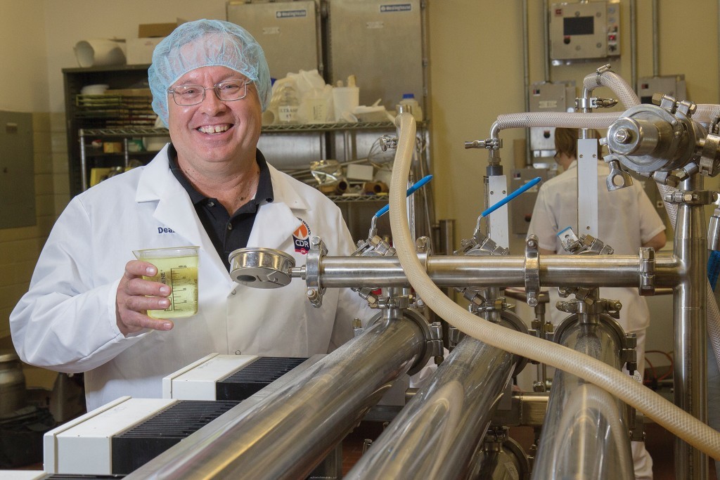 Photo: Dean Sommer showing a beaker of acid whey