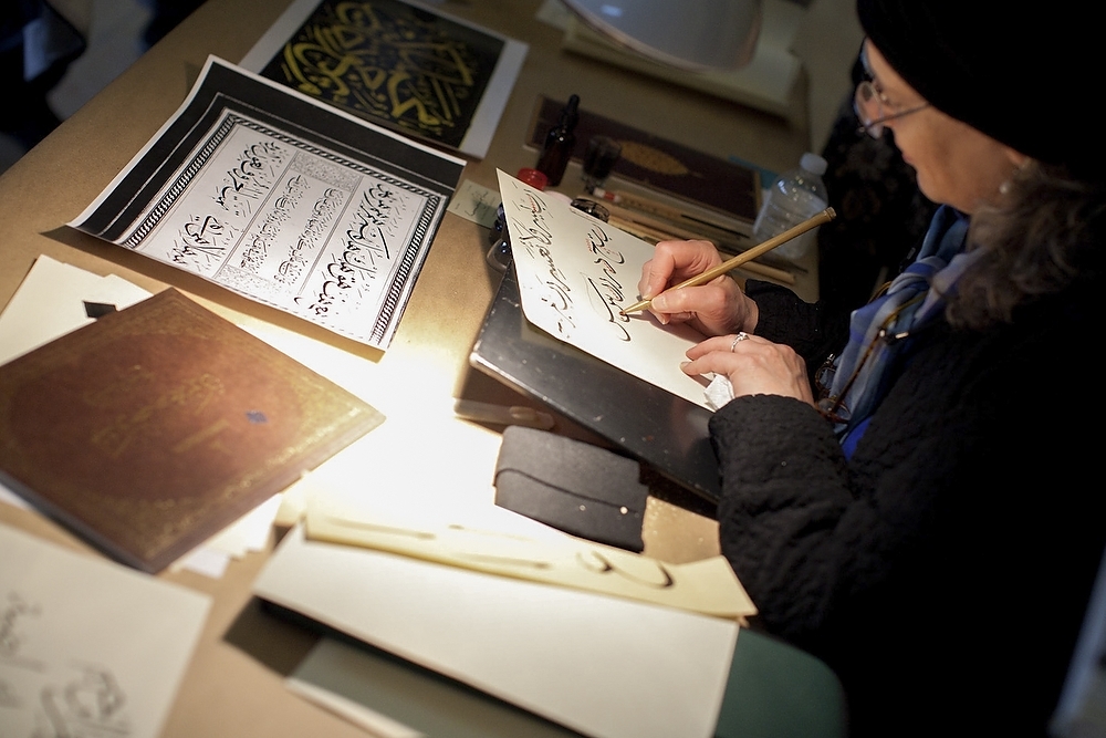 Photo: Calligrapher writing Arabic letters