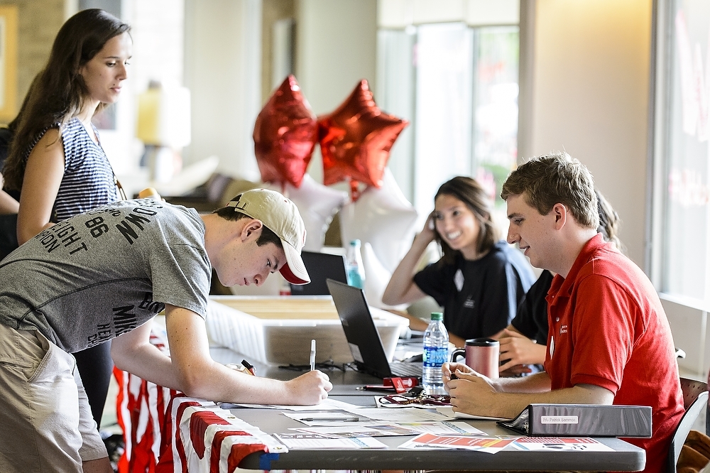 Photo: Student signing card at registration table