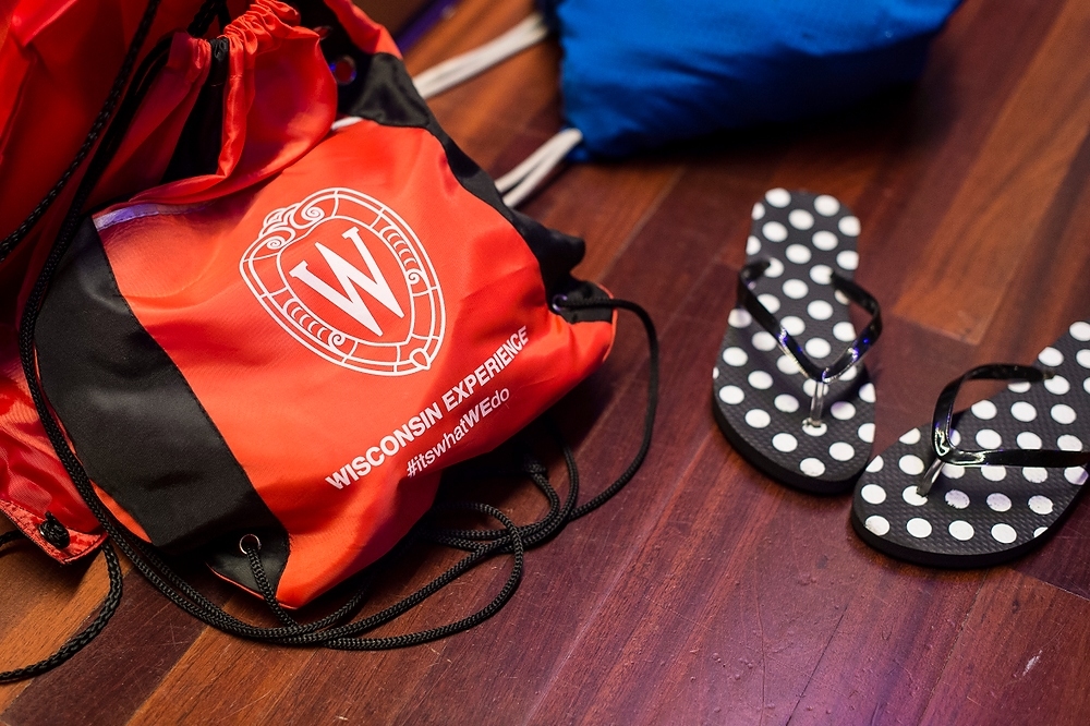 Photo: A Wisconsin Experience backpack and flip flops sit to the side as  students learn ballroom dance steps.