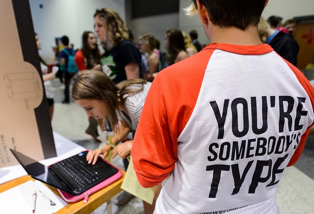 Photo: a member of the American Red Cross Club of UW–Madison helps a student sign up for more information