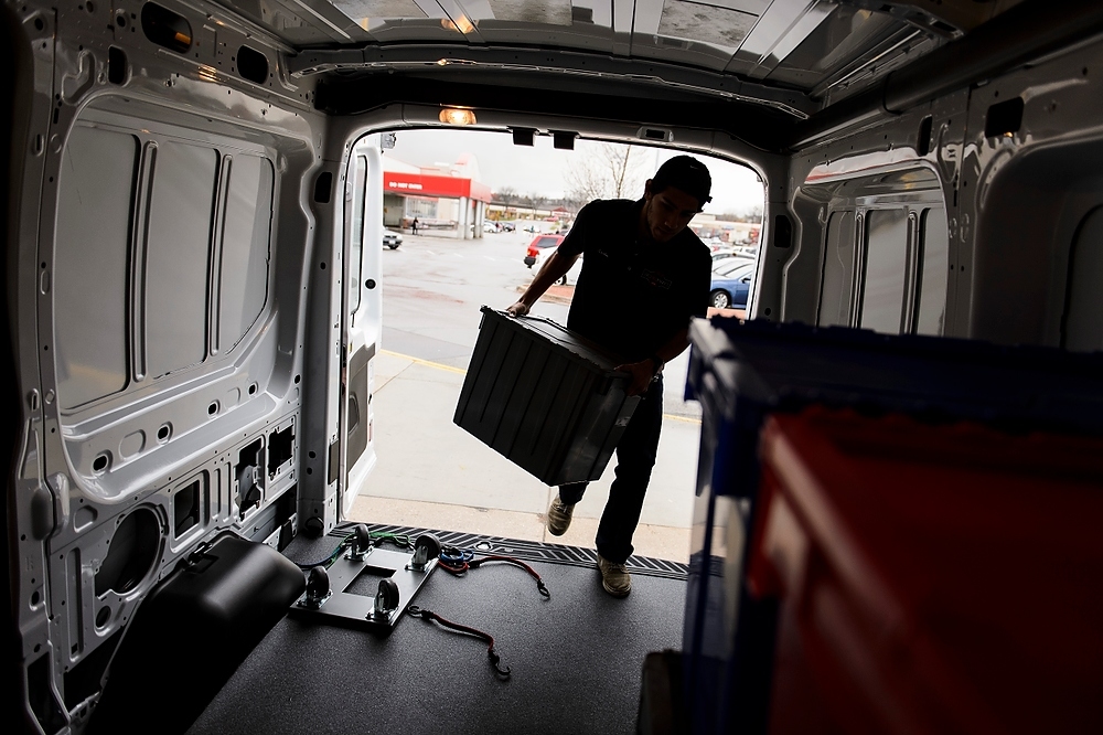 Photo: Employee loading food order into a van