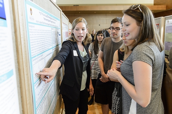 Photo: Student pointing to research poster