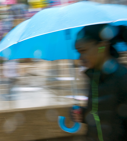 Photo of pedestrian walking with umbrella