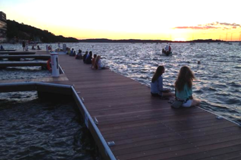 Photo: people sitting along pier