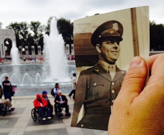 Photo: Mike Garren holding picture of father in uniform at WWII Memorial