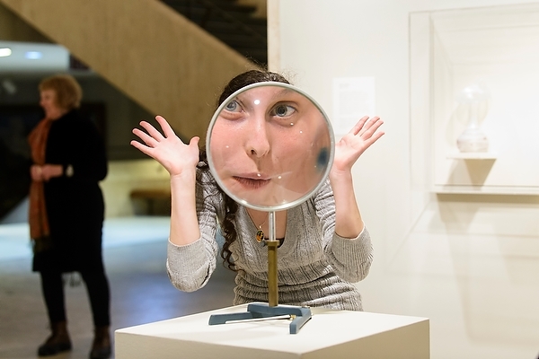 Photo: woman looking through large convex lens
