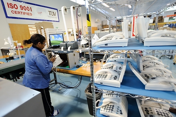 Photo: A worker programs and tests a new line of CapTel, a captioned telephone system, at one of Ultratec’s multiple telecommunication and manufacturing facilities at the University Research Park