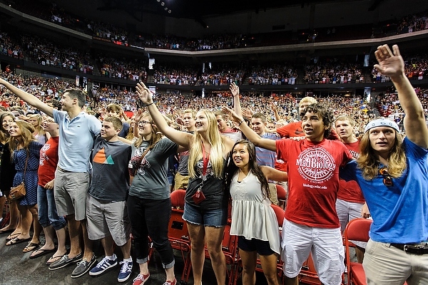 Photo: Students raising hands and singing "Varsity" in Kohl Center
