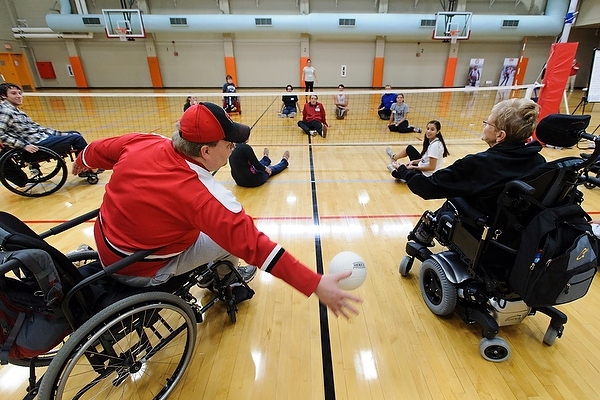 Photo: People playing sitting volleyball, some in wheelchairs
