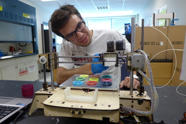 Photo: Chase Haider adjusts a commercial 3-D printer