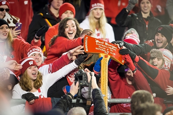 Photo: Badger fans touch the Paul Bunyan Axe as Wisconsin players celebrate the team’s retention of the football trophy 