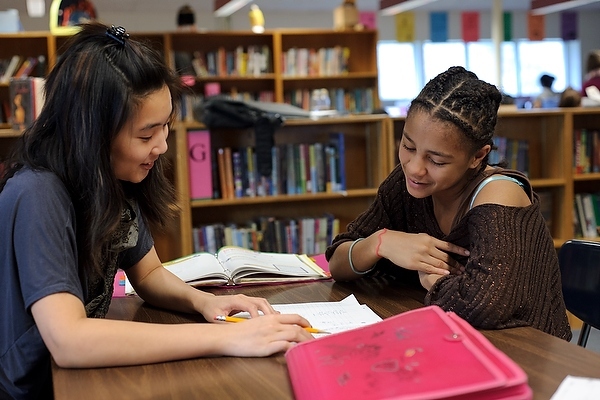 Sarah Soon, left, a University of Wisconsin–Madison undergraduate from Singapore and member of Badger Volunteers, reviews a math exercise with sixth grader Chaya Miller during an after-school tutoring program at Velma Hamilton Middle School in Madison, Wis. Badger Volunteers, initiated in Fall 2008 and coordinated by the UW–Madison Morgridge Center for Public Service, sends 70 student teams to 50 community-partner sites. More than 400 students participate each semester.
