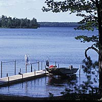 Photo of an empty pier on a quiet Trout Lake in summer.