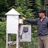 Photo of Nicholas Preston with a total suspended particle collector.