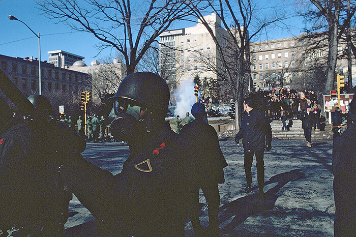 Chaos on campus with National Guardsmen wearing gas masks dispersing tear gas into a crowd of protestors on campus. Photo by John Wolf
