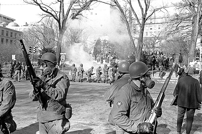 Guardsmen in foreground and in the distance as tear gas is dispersed on campus. Photo by John Wolf