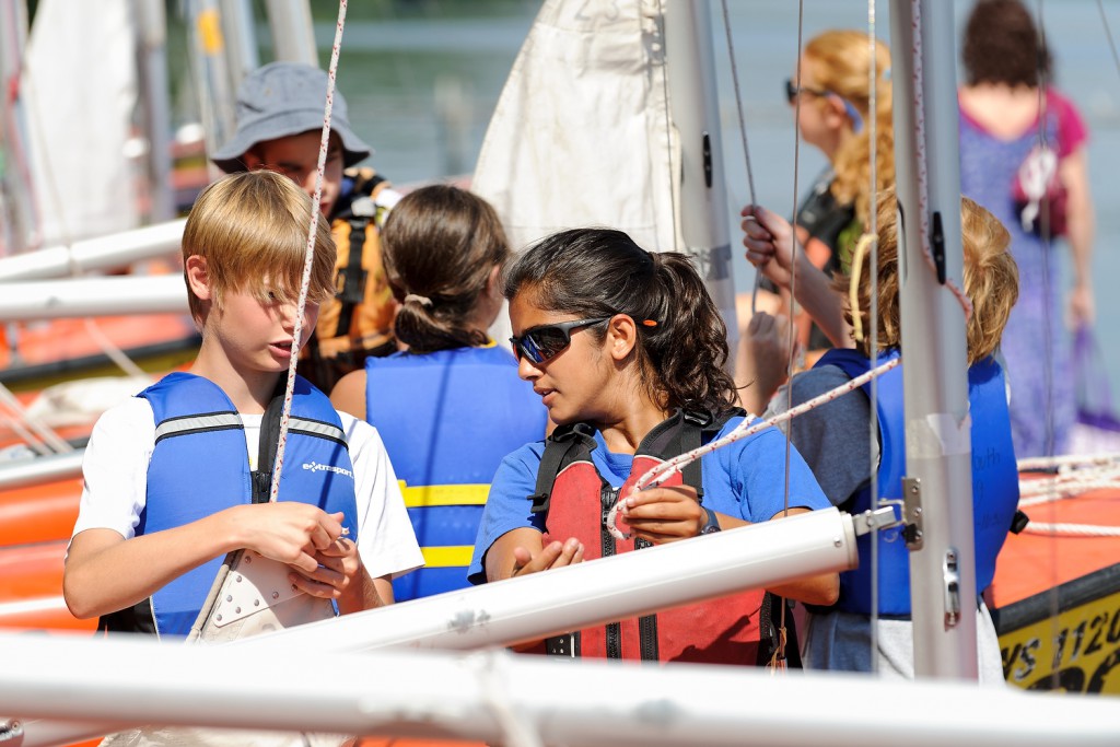 And now for the real thing: Undergraduate student Tulika Singh, right, helps a young student learn to rig a sailboat during one of the one- and two-week Hoofer day camps offered for participants ages 10-18.