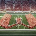 More than a thousand students flow onto the football field at Camp Randall Stadium at the University of Wisconsin-Madison in the shape of a W.
