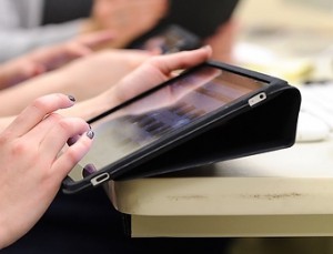 Photo: Someone's fingers on a tablet.