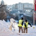 Hardworking grounds crew members shovel snow and clear the steps to the Lincoln Terrace near Bascom Hall during an early winter morning on Monday, Feb. 2. In the background on Bascom Hill hang banners featuring the university’s W crest.