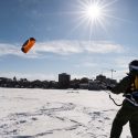 Undergraduate Ben Witman practices his snow-kiting skills during a Hoofer Sailing Club class on frozen and snow-covered Lake Mendota near the University of Wisconsin-Madison during winter on Feb. 26, 2015. The class had just advanced to their B-level rating, which includes snow kiting with a harness but boots rather than a windsurfing board. On the horizon is the dome of Wisconsin State Capitol building. (Photo by Jeff Miller/UW-Madison)