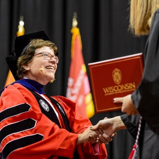 Chancellor Rebecca Blank shakes the hand of a graduate.