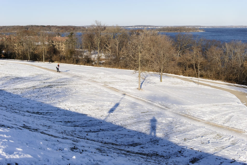 A bundled pedestrian walks across a snowy path on Observatory Hill, one of the areas under study as part of the 2015 Master Plan.