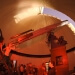 With moonlight shining in an open slit of the Washburn Observatory dome, the general public takes advantage of a once-monthly opportunity for nighttime public viewing of the stars using the observatory's vintage telescope in 2012. 