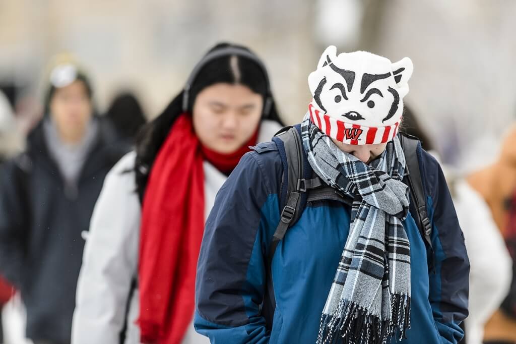 A student keeps warm in her Badger hat as she walks along Linden Drive at the University of Wisconsin-Madison during a class change on Jan. 26, 2016. (Photo by Bryce Richter / UW-Madison)