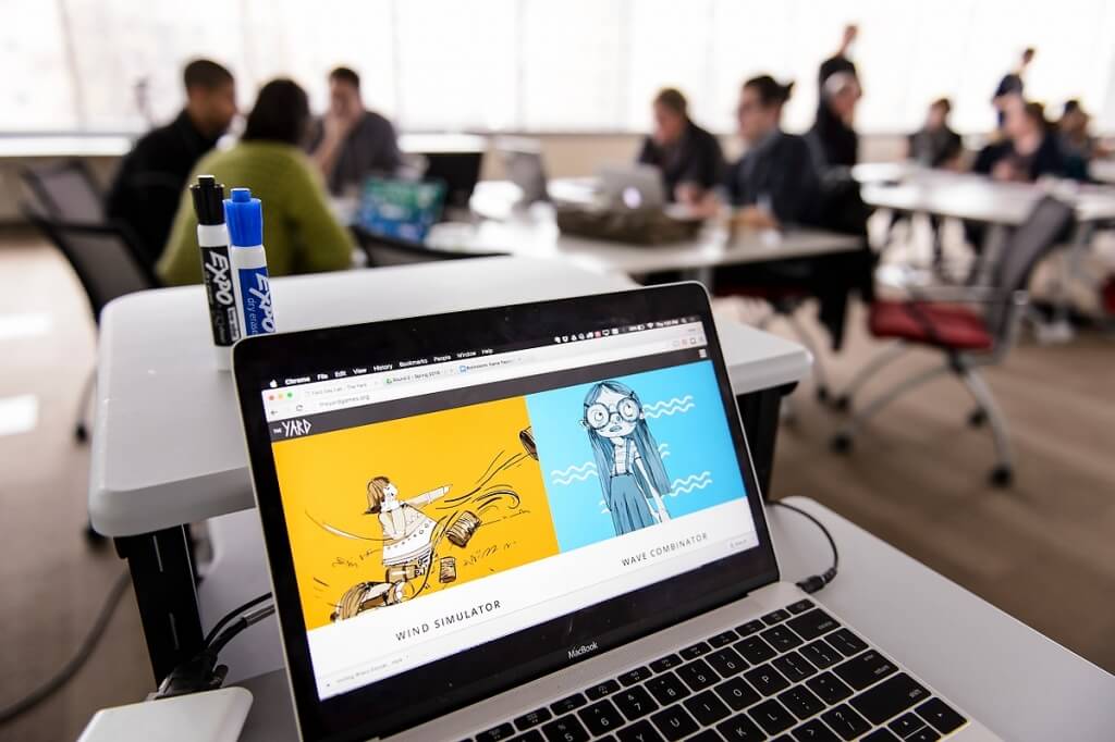 Two previously-developed computer games — Wind Simulator and Wave Combinator — are displayed on a laptop during the Field Day Lab mini-game design workshop.