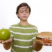 Photo: Boy with apple in one hand and sandwich in the other