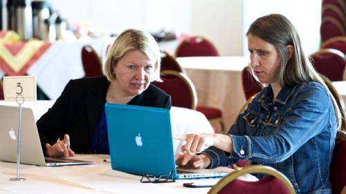 Photo: Two women looking at laptops