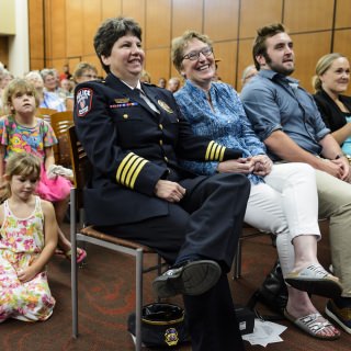 Riseling, her wife, Joanne Berg, and their children, Nate and Erin Nagy, laugh while watching a video tribute.