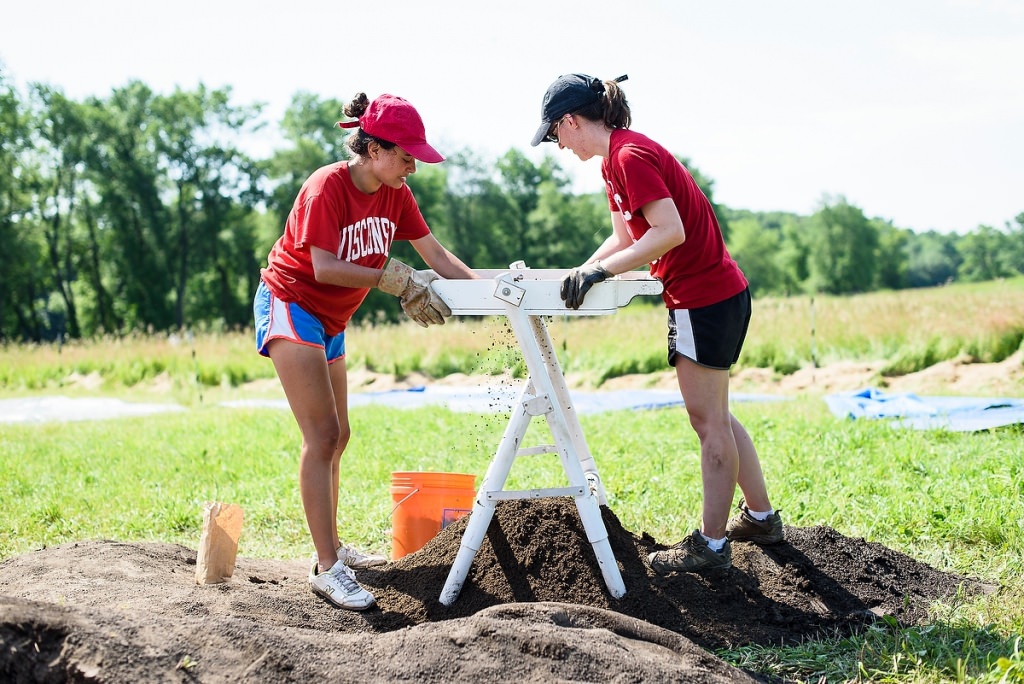 Lupe Granados, left, and field manager Marissa Lee sift soil as undergraduate students in a University of Wisconsin-Madison summer session field course continue archeology site excavation in a grassy field at Aztalan State Park near Lake Mills, Wisconsin. The class and related research, led by Anthropology Professor Sissel Schroeder, aims to better understand the daily lives of native people who called Aztalan home a millennium ago.
