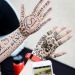 Photo: Two hands with henna pictures and words