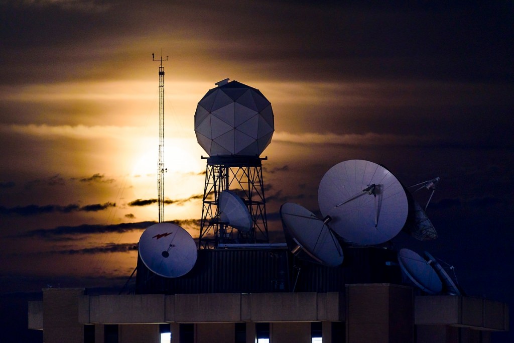 Photo: Moon behind instruments on building roof