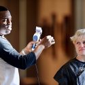 Photo: Artist — and barber — Faisal Abdu'Allah talks about his work while cutting the hair of volunteer Alison Jones Chaim during a live salon held in the Chazen Museum of Art lobby while he was serving as the Arts Institute's Spring 2013 Interdisciplinary Artist in Residence.