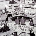 Pat Kubly, chairman of the board of Colony Brands and son of Ray Kubly, Sr., is pictured standing with his hand above the date 1987 in a collage of historical company photos on display at  Colony Brands.