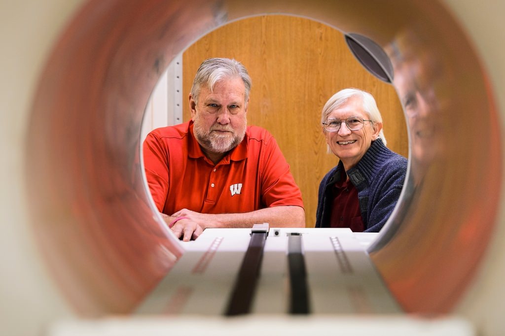 Frank Rath, left, a faculty associate in the College of Engineering, and Bruce Thomadsen, professor of medical physics, are pictured looking through the opening of a piece of radiotherapy treatment equipment at the Carbone Cancer Center. Thomadsen helped found the Center for the Assessment of Radiological Science as a way to help monitor and improve incidents of radiation-treatment safety in health care. 