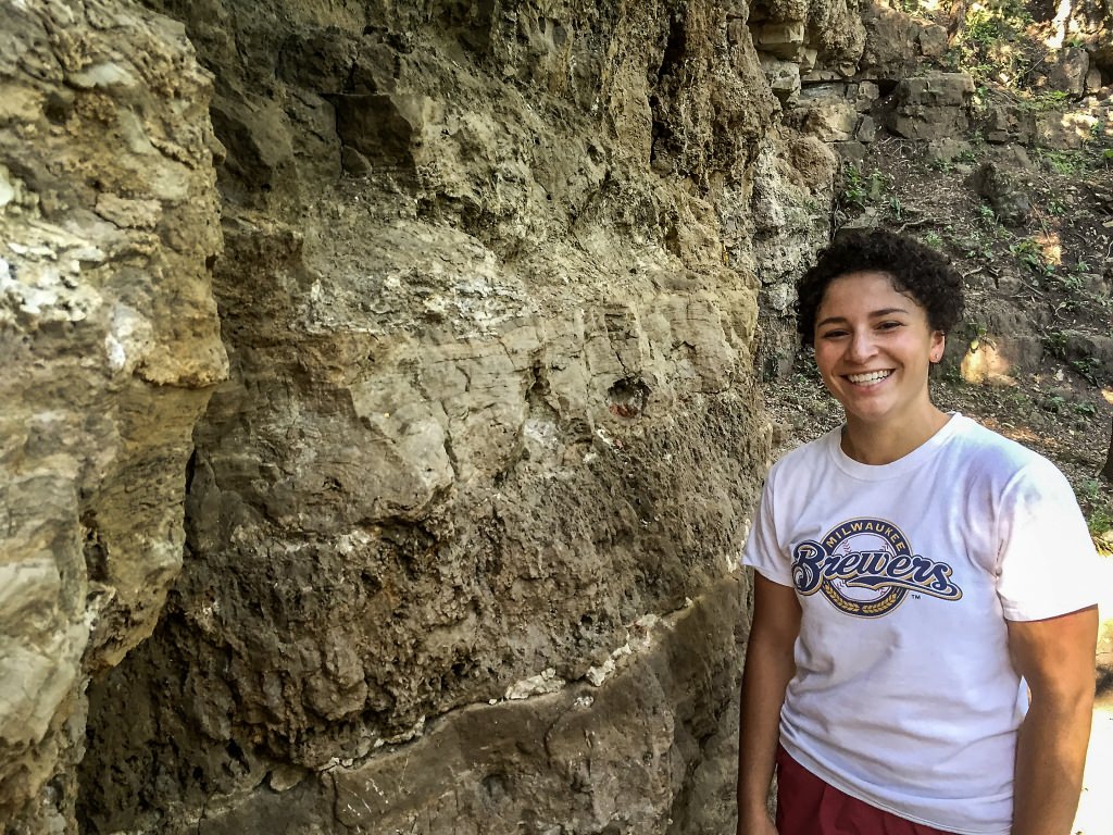 Julia Wilcots, a Madison native who was then at Princeton University, at a rock quarry in Shorewood Hills, Wisconsin. The layers at her head and chest level are both composed of different types of stromatolites. 