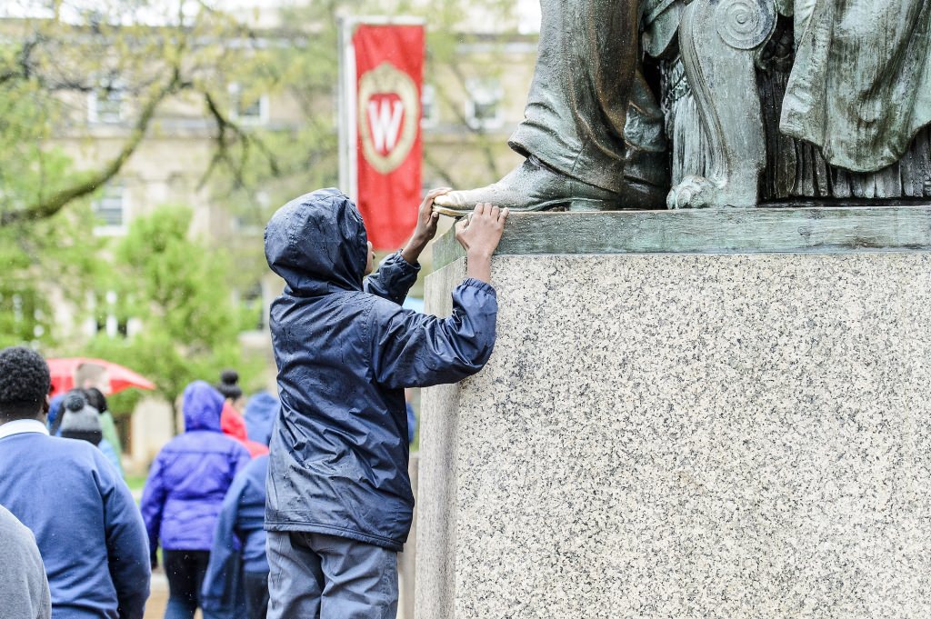Students from the Milwaukee Excellence Charter School take a tour of Bascom Hill and learn about the history of its buildings and the Abraham Lincoln statue during a Bucky's Classroom event at the University of Wisconsin-Madison on April 27, 2017. Bucky's Classroom is a UW outreach program design to partner with K-8 Wisconsin schools to promote the value of higher education and provide classroom resources and an opportunity to directly engage with university students. (Photo by Bryce Richter / UW-Madison)