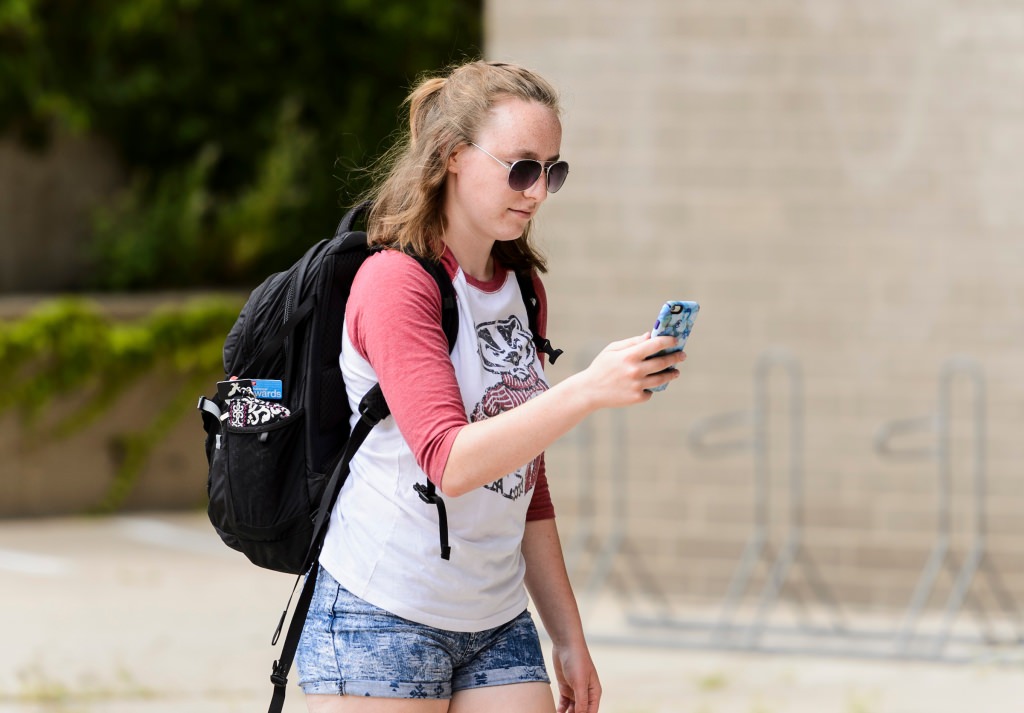 Photo: Student looking at cellphone while playing Pokemon GO