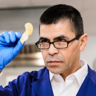 Equipment operator and staff member Sam Perez visually inspects and numerically rates a fried-potato chip as he conducts biweekly, quality-control lab tests on a variety of chipping potatoes stored at the University of Wisconsin-Madison Hancock Agricultural Research Station (HARS) in Hancock, Wis., on April 6, 2017. HARS provides bulk-food storage and laboratory-testing services to a number of small- to medium-sized farm customers in the region. Perez is one of eight recipients of a 2017 University Staff Recognition Award (USRA). (Photo by Jeff Miller/UW-Madison)