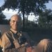 Photo: Aldo Leopold sitting outdoors with binoculars