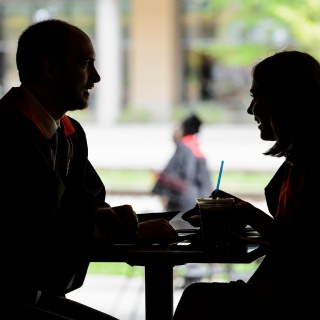 Seen in silhouette, soon-to-be graduates Austin Moore and Elizabeth Platt enjoy a drink at Union South before the start of UW-Madison's spring commencement ceremony.