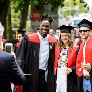 From left, student athletes Nigel Hayes (basketball), Annie Tamblyn (swimming) and Zak Showalter (basketball) stop for a photo near the Camp Randall Memorial Arch.